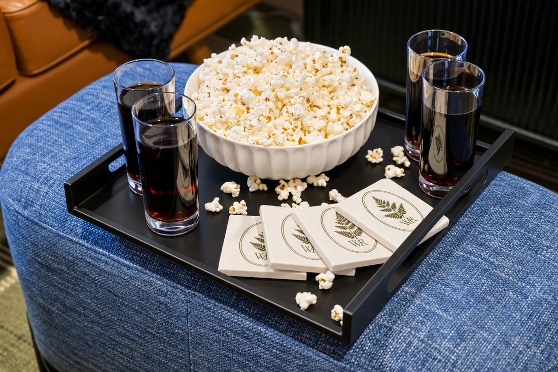 Popcorn and drinks on a tray with Wilder Ridge coasters in the movie lounge
